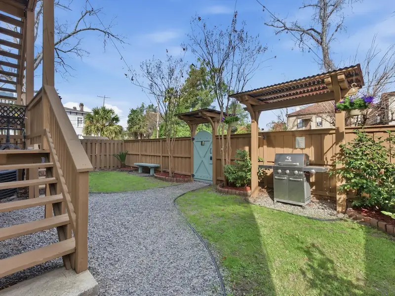 Suite 314A backyard with gas grill at Savannah vacation rental â€” pergola green lawn private outdoor space