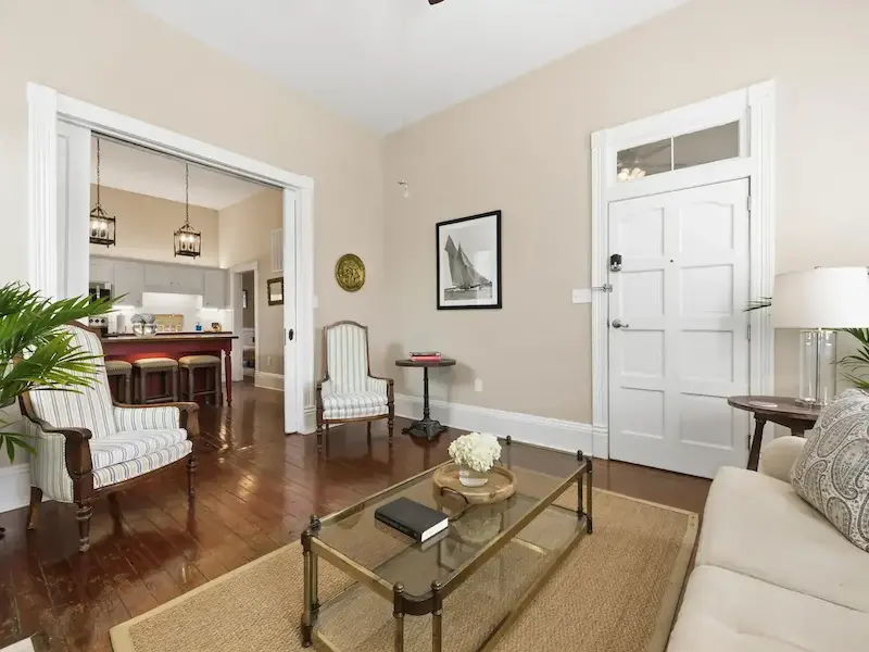 Suite 314A historic Savannah living room â€” soaring ceilings, heart-pine floors, fireplace and palms