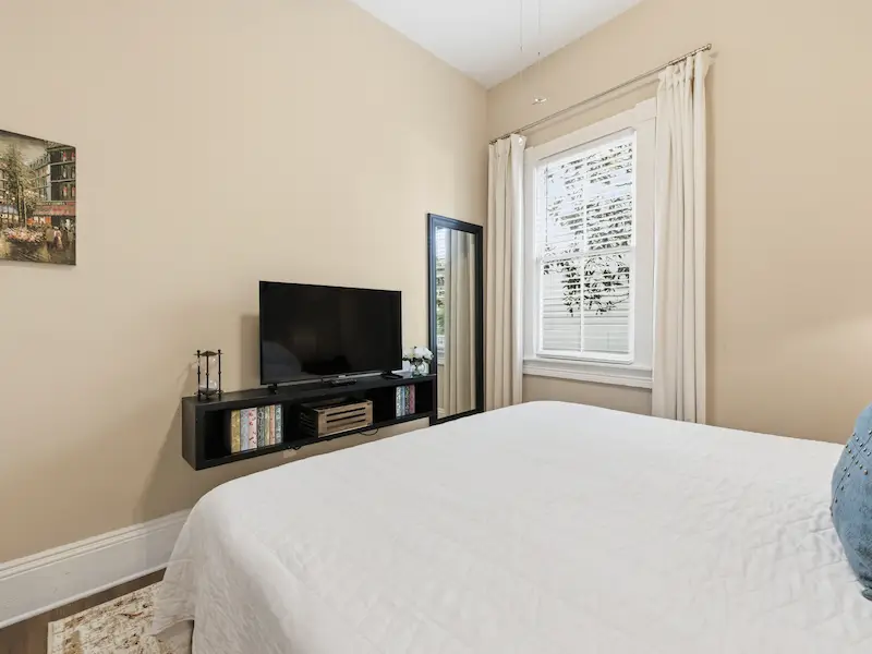 Suite 314A king bedroom Victorian District Savannah rental â€” sailboat art closet hardwood floors