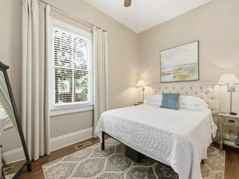 Suite 314A queen bedroom at The Wilder House Savannah â€” white bedding smart TV dresser hardwood floors natural light