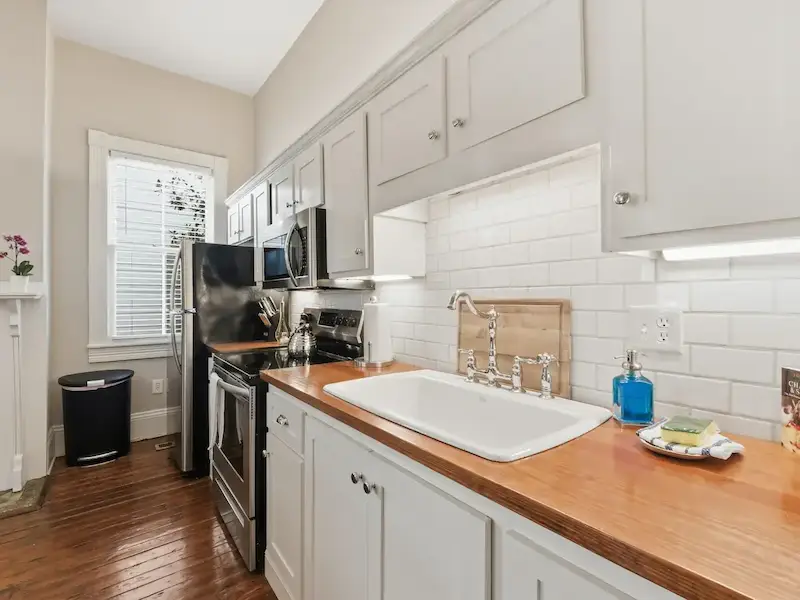 Suite 314A Savannah Airbnb kitchen â€” butcher block wood countertops subway tile backsplash farmhouse sink