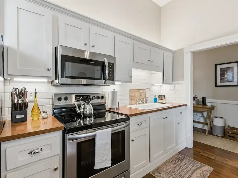 Suite 314A Victorian District Savannah kitchen â€” stainless steel appliances subway tile white shaker cabinets