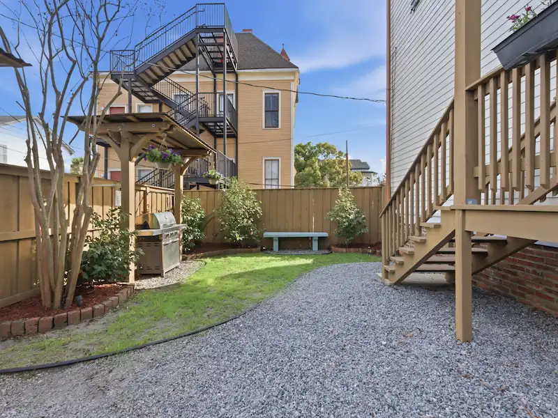 The Wilder House private deck Savannah â€” bistro table orange juice morning breakfast with garden tree views
